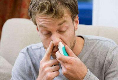 Парень капает нос назонексом